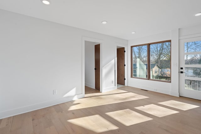 spare room with a wealth of natural light and light hardwood / wood-style flooring