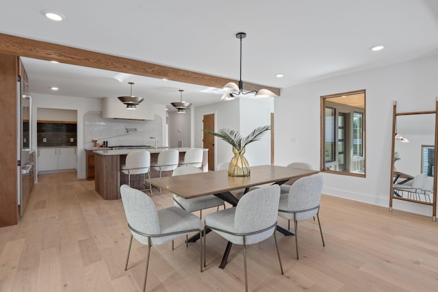 dining area with beamed ceiling and light hardwood / wood-style floors