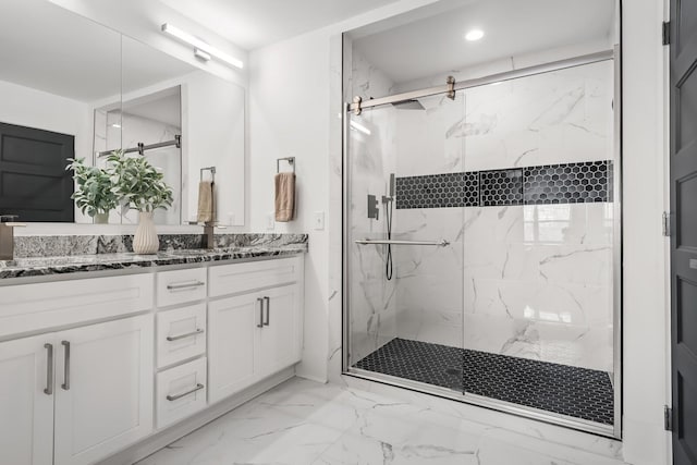 bathroom with recessed lighting, marble finish floor, a marble finish shower, and double vanity