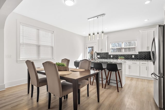 dining area featuring recessed lighting, light wood-style flooring, and baseboards