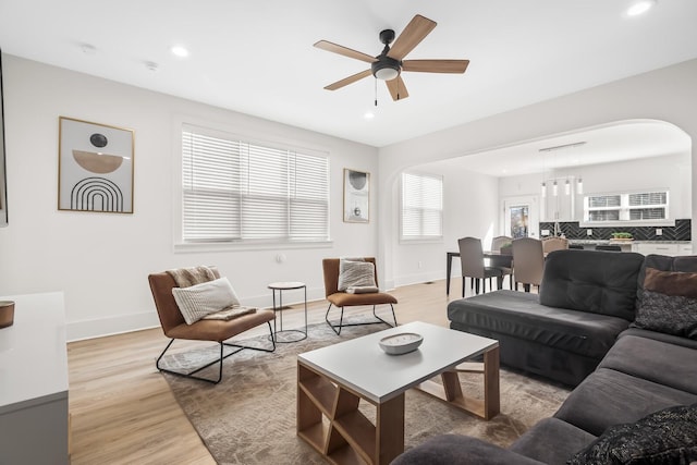 living area featuring light wood finished floors, plenty of natural light, baseboards, and recessed lighting