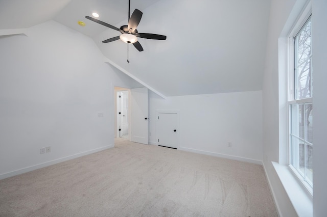 additional living space featuring lofted ceiling, light colored carpet, and ceiling fan