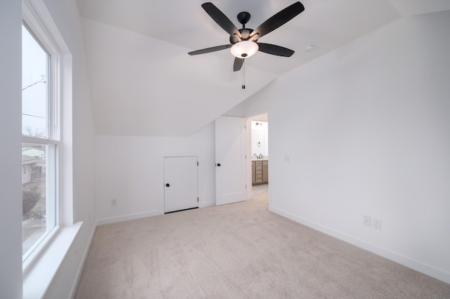 additional living space with vaulted ceiling and light carpet