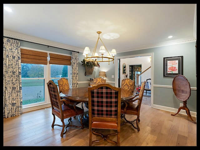 dining room featuring stairway, an inviting chandelier, light wood-style floors, ornamental molding, and baseboards