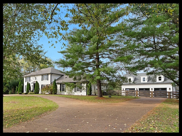 view of front of house with a front lawn, fence, and a detached garage