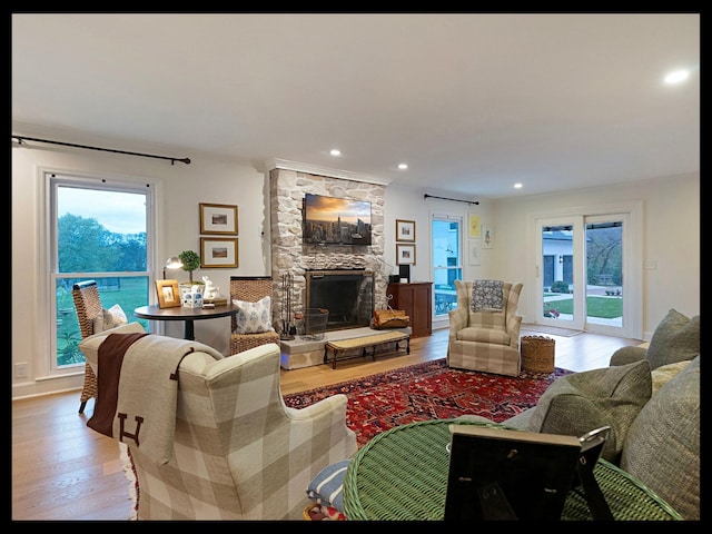 living area featuring light wood finished floors, a fireplace, and recessed lighting