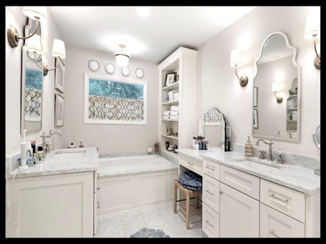 full bath featuring marble finish floor, a garden tub, and vanity