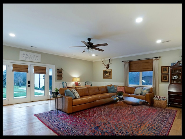 living area featuring recessed lighting, wood finished floors, ornamental molding, french doors, and wainscoting