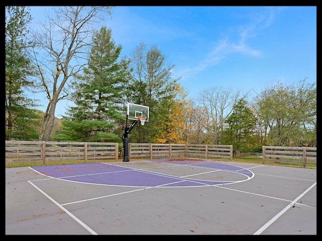 view of basketball court featuring basketball hoop and fence