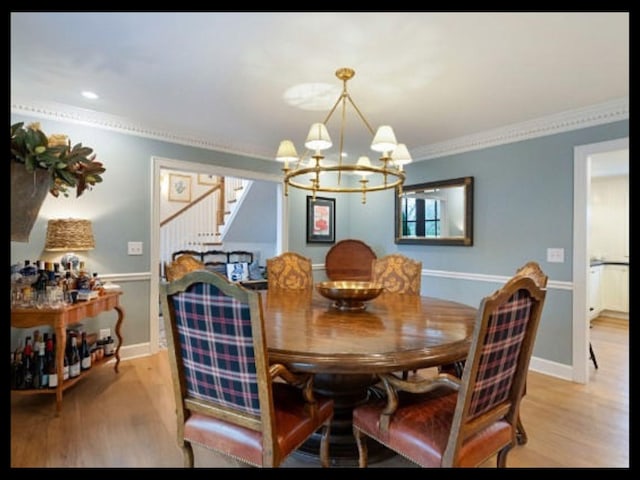 dining room featuring baseboards, light wood-style flooring, stairway, crown molding, and a chandelier