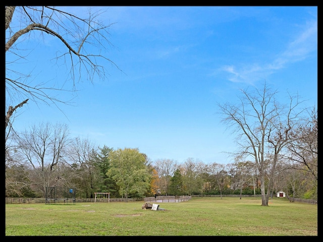 view of community with a lawn and fence