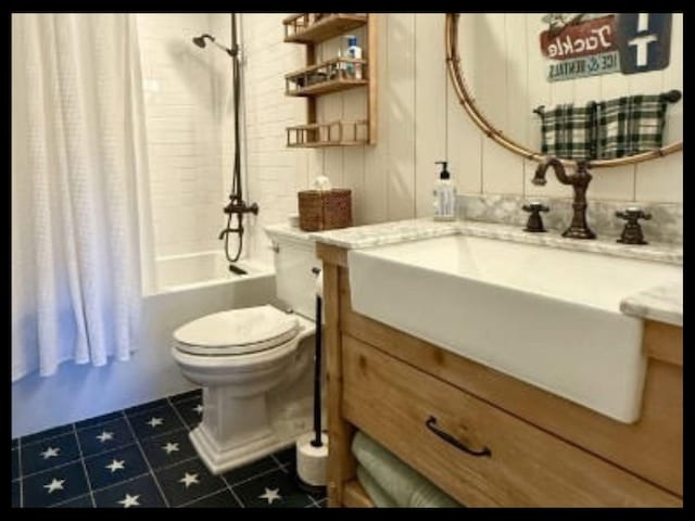 bathroom featuring tile patterned flooring, vanity, toilet, and shower / tub combo with curtain