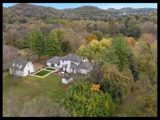 birds eye view of property featuring a mountain view and a view of trees