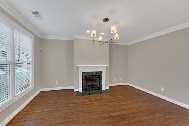 unfurnished living room featuring ornamental molding, dark hardwood / wood-style flooring, an inviting chandelier, and a high end fireplace