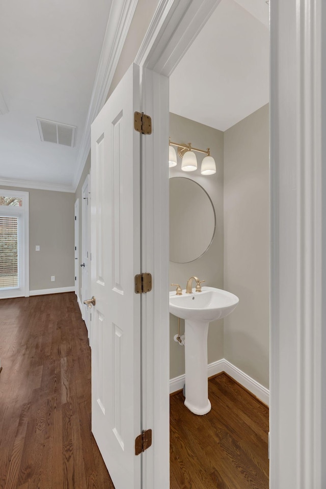 bathroom featuring crown molding, sink, and hardwood / wood-style floors