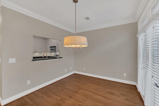 unfurnished dining area with ornamental molding and hardwood / wood-style floors