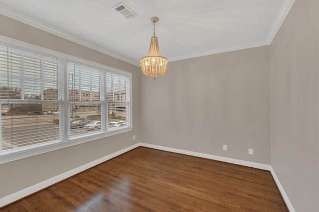 spare room featuring crown molding, dark hardwood / wood-style floors, and a chandelier