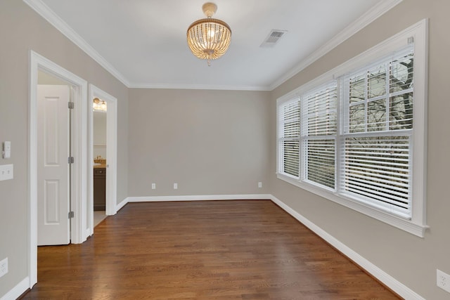 empty room featuring a notable chandelier, ornamental molding, and dark hardwood / wood-style floors