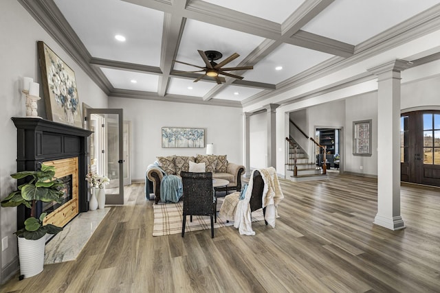 living room featuring hardwood / wood-style flooring, ceiling fan, beam ceiling, coffered ceiling, and ornate columns