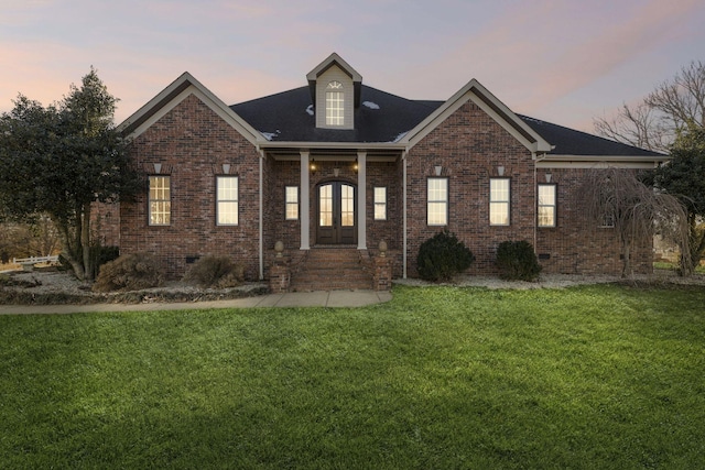 view of front of house featuring french doors and a lawn