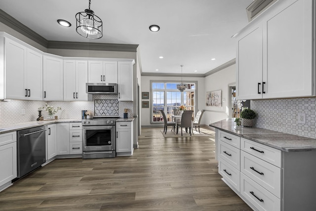 kitchen with appliances with stainless steel finishes, pendant lighting, white cabinetry, a chandelier, and dark wood-type flooring