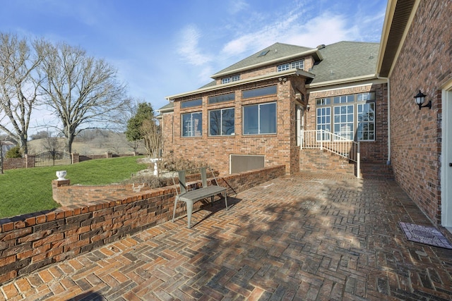 back of property with a patio area and a lawn