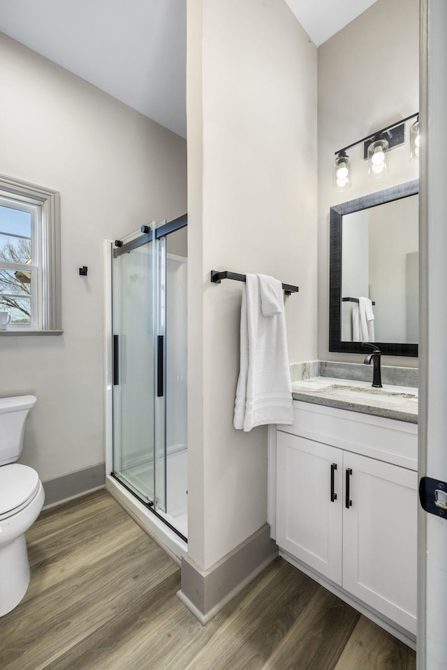 bathroom with vanity, toilet, an enclosed shower, and hardwood / wood-style floors