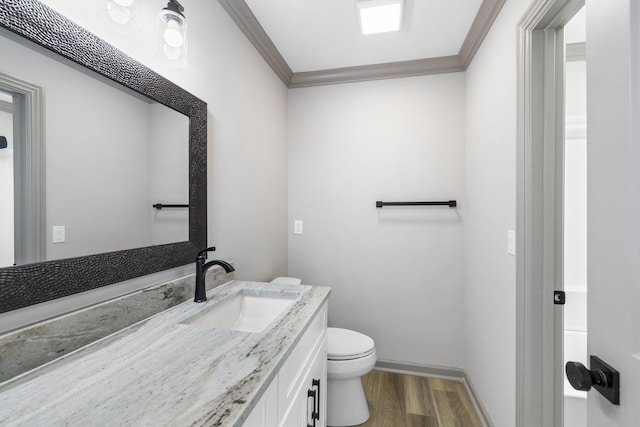 bathroom featuring crown molding, vanity, toilet, and hardwood / wood-style floors