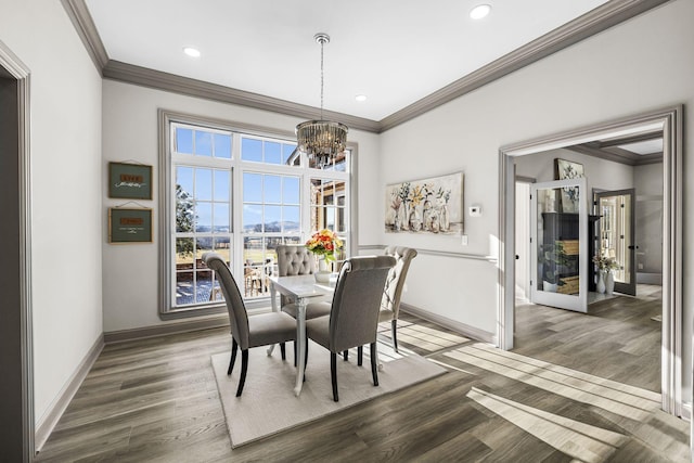 dining room with dark wood-type flooring, crown molding, and a chandelier