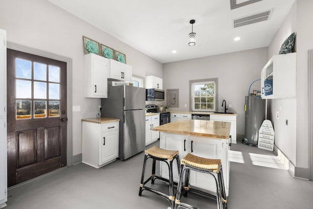 kitchen with stainless steel appliances, white cabinetry, and a kitchen island