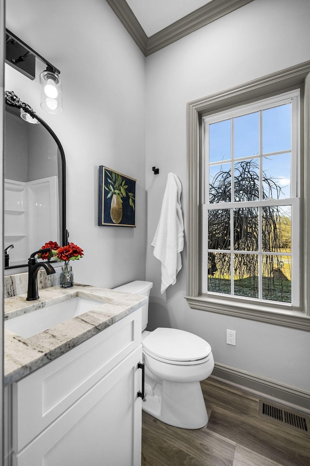 bathroom featuring toilet, a shower, crown molding, wood-type flooring, and vanity