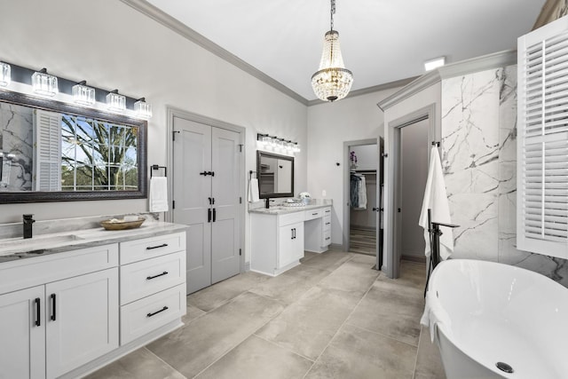 bathroom featuring crown molding, tile walls, vanity, a bath, and a notable chandelier