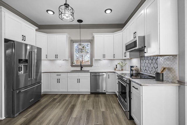 kitchen featuring pendant lighting, sink, stainless steel appliances, light stone countertops, and white cabinets