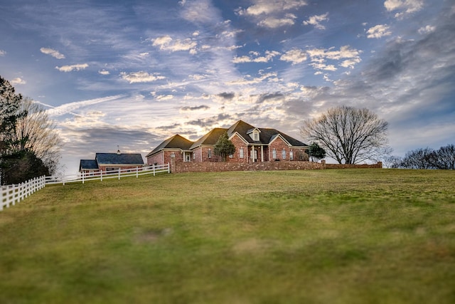 yard at dusk featuring a rural view