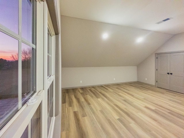 bonus room with lofted ceiling and light hardwood / wood-style floors