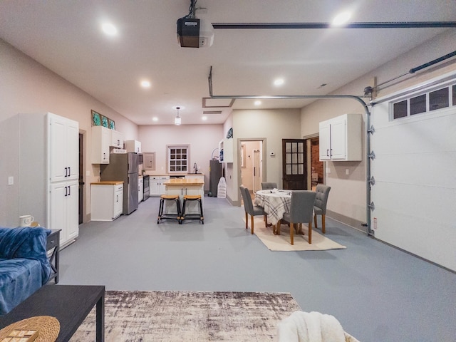 garage with a garage door opener and stainless steel fridge