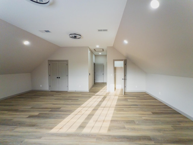 additional living space with lofted ceiling and light wood-type flooring