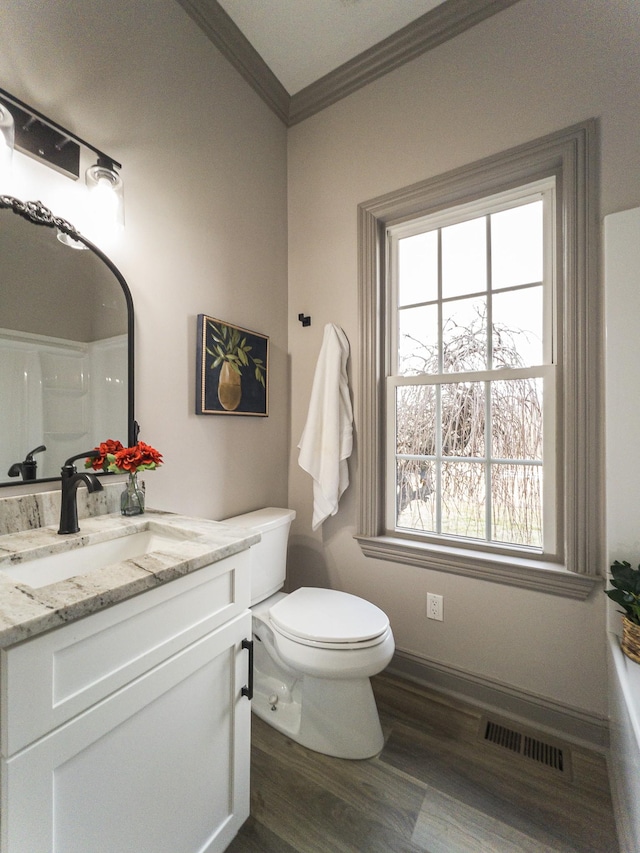 bathroom featuring vanity, crown molding, wood-type flooring, and toilet