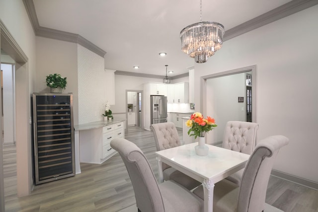 dining space featuring hardwood / wood-style flooring, ornamental molding, wine cooler, and a chandelier