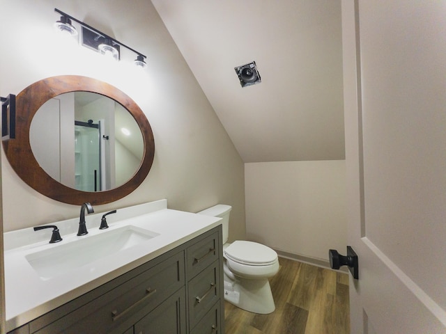 bathroom with vanity, toilet, vaulted ceiling, and wood-type flooring