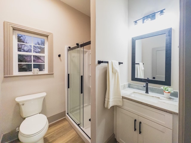 bathroom featuring vanity, wood-type flooring, toilet, and walk in shower
