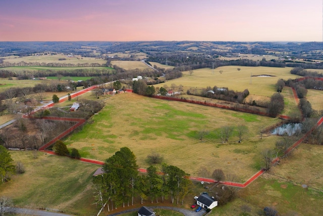 aerial view at dusk featuring a water view and a rural view