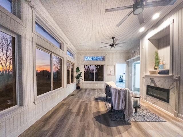 sunroom / solarium featuring wood ceiling, a premium fireplace, and ceiling fan