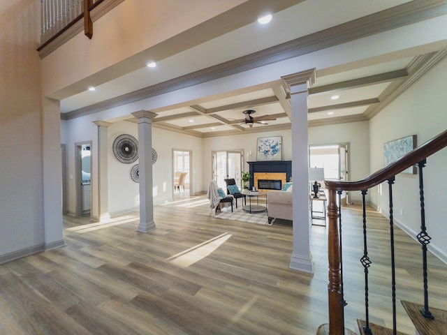 interior space with ornate columns, wood-type flooring, coffered ceiling, ceiling fan, and beam ceiling