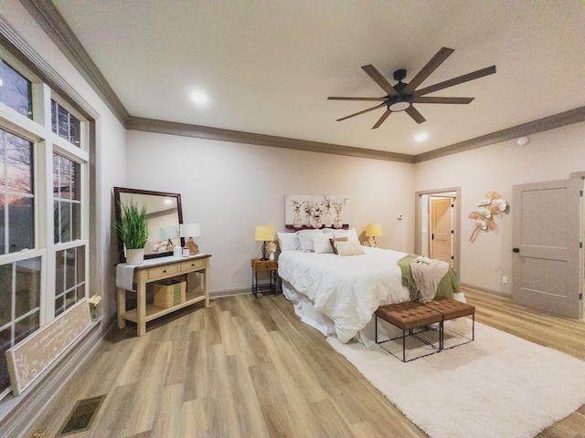 bedroom with ornamental molding, ceiling fan, and light hardwood / wood-style flooring