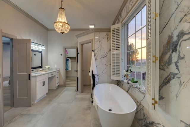 bathroom featuring crown molding, tile walls, an inviting chandelier, vanity, and a tub to relax in