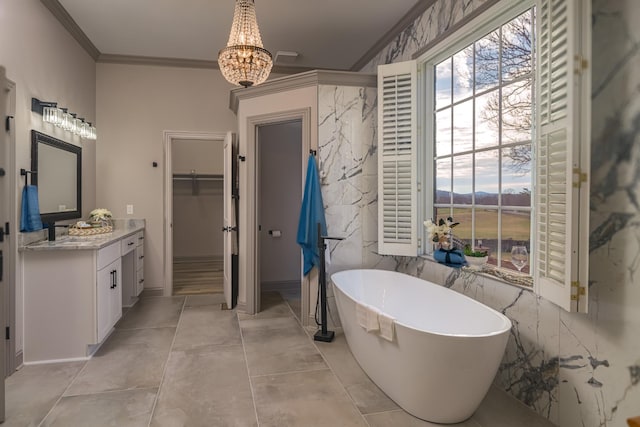 bathroom featuring crown molding, a notable chandelier, vanity, and a tub