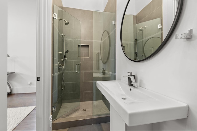 bathroom with sink, hardwood / wood-style floors, and a shower with shower door