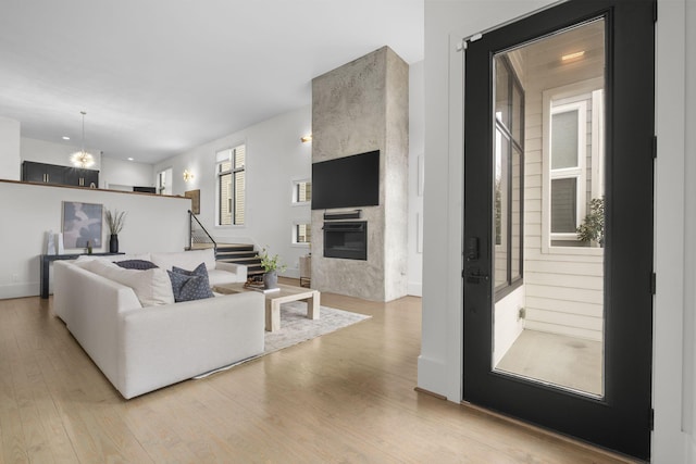 living room featuring light hardwood / wood-style flooring and a large fireplace