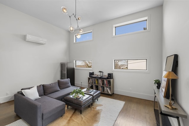 living room featuring a towering ceiling, wood-type flooring, and a wall mounted AC